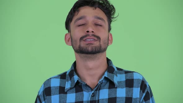 Face of Happy Young Bearded Persian Hipster Man Relaxing with Eyes Closed