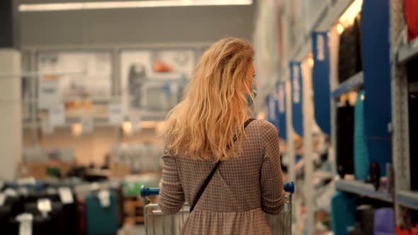 Woman Shopping And Walks Through Supermarket With Basket. Girl In Face Mask Shopping In Market.