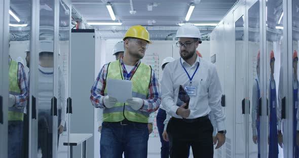 Electrical Workers Walking and Reviewing Documents