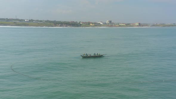 Fishermen at sea casting net in Ghana