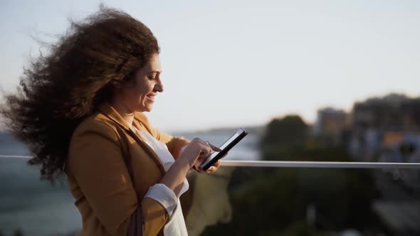 Fashionable Young Businesswoman Working Online Using Tablet in City