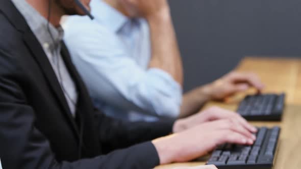 Smiling customer service executives talking on headset at desk 4k