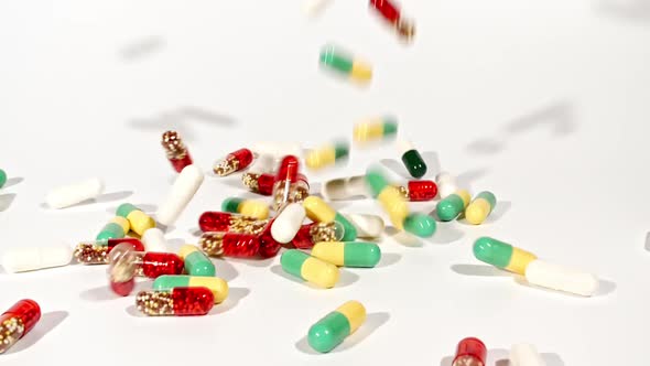 Closeup of Different Medical Pills Falling on Table on White Background
