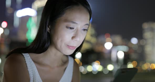 Woman working on cellphone at night 