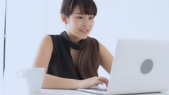 Young asian woman smile and happy working online laptop computer success.