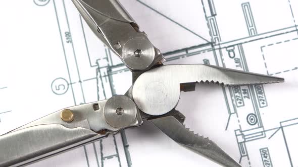 Metal Round-nose Pliers on Building Plan, Scheme, Rotation, Close Up