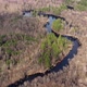 Aerial view of the river between the pines. Flying over a winding riverbed surrounded by treetops - VideoHive Item for Sale