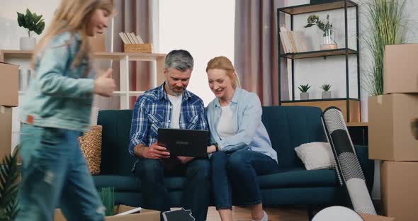 Couple Discussing About Room Design in New Apartment with a Lot of Carton Boxes