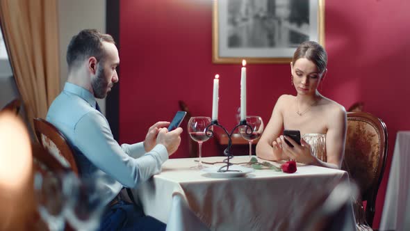 Couple Chatting Use Smartphone During Boring Romantic Date