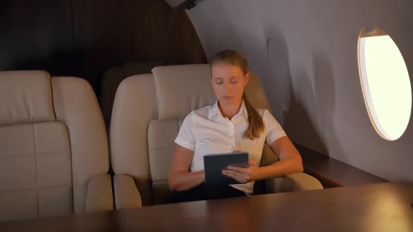 Businesswoman with Tablet Pc Inside of Business Jet