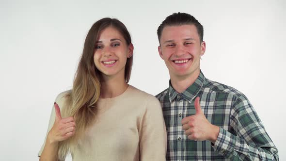 Happy Young Loving Couple Smiling To the Camera, Showing Thumbs Up