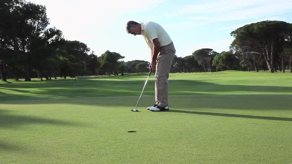 Mature man playing golf on golf course