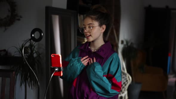 young influencer girl records video on her phone for social media at home