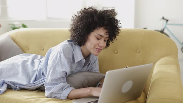 Woman Shopping Online with Credit Card on the Sofa