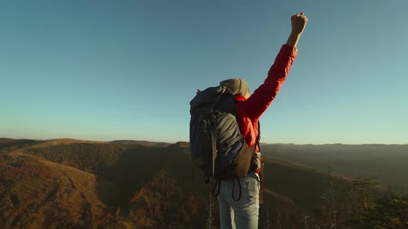 Slow Motion Camera Movement Around Behind Adventurous Woman Hiker Backpacker in Red Jacket and Jeans