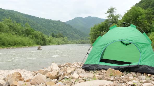 Green Tent on the Rocky Bank of a Mountain River Yukon Tributary Klondike Canada