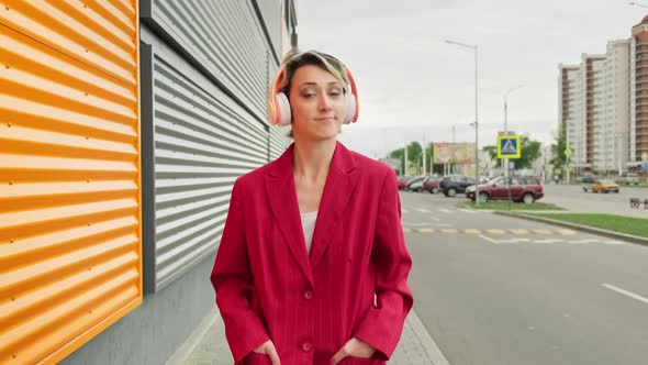 Young Woman Walking at City Street with Headphones
