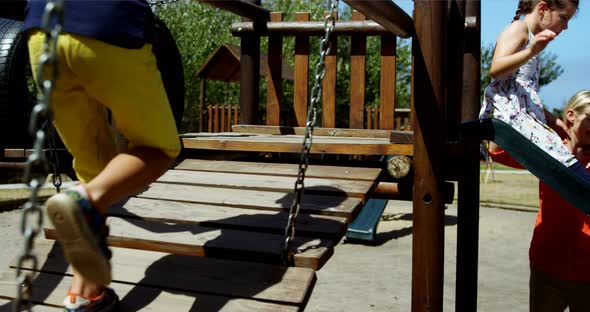 Trainer assisting schoolkids while playing in playground