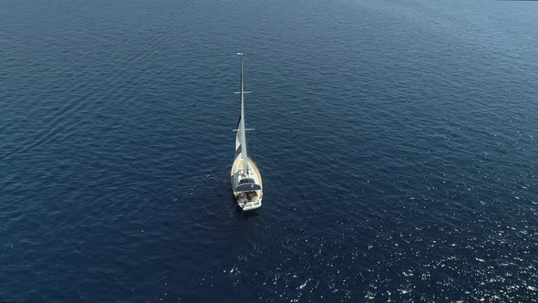 Aerial view of a sailboat driving forward in the mediterranean sea, Greece.