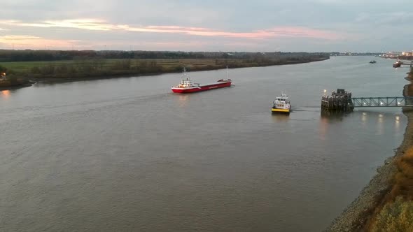 Tanker ship is leaving Antwerp while small transport boat is docking