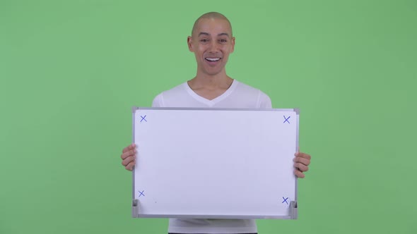 Happy Handsome Bald Man Holding White Board and Looking Surprised