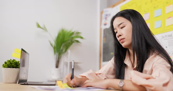 Happy asian woman working at table