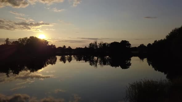 1 million $ aerial drone flight slider fly sideways at summer sunset on a lake at small village in B