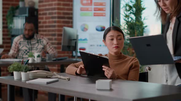 Company Employees Looking at Statistics on Laptop