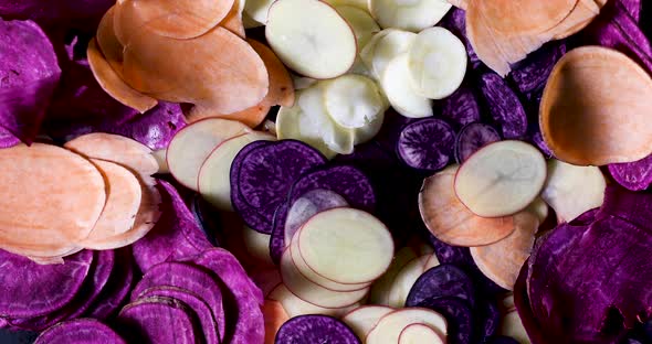 Slices of old potatoe types and parsnip for homemade chips