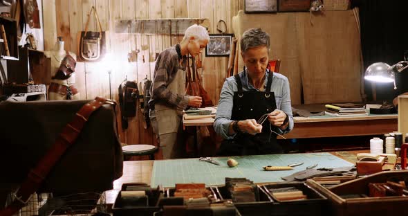 Craftswoman stitching a piece of leather