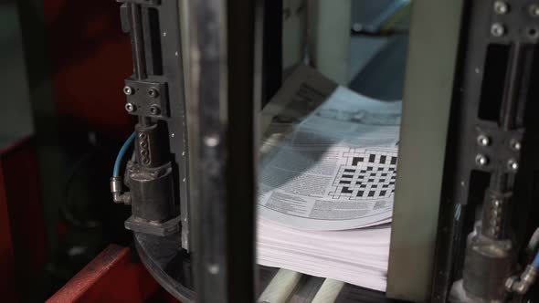 Newspapers Fall Into Large Pile and Move Along the Conveyor Line