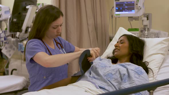 A young nurse performs a patient evaluation to get her vital signs.