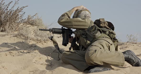 Israeli soldier taking cover from enemy fire during combat