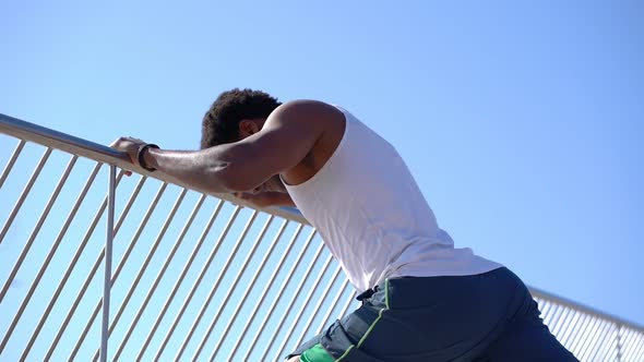 Smiling African American Sportsman Exercising Against Blue Sky