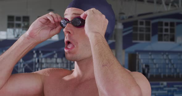 Swimmer putting his pool goggles 