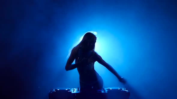 Dark Studio. Rhythmic Dancing Woman DJ of Sounding Track