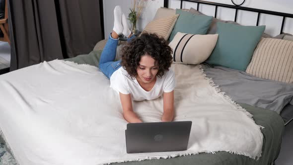 Smiling Hispanic Curly Woman Student Study Uses Laptop Distance Education