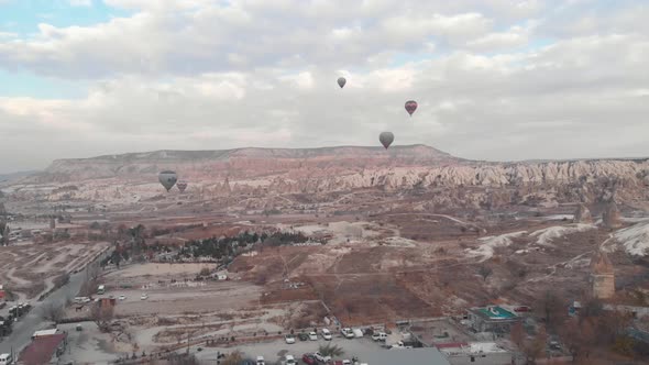 Aerial 4k drone footage of hot air balloons over the desert landscape of Cappadocia, Turkey.