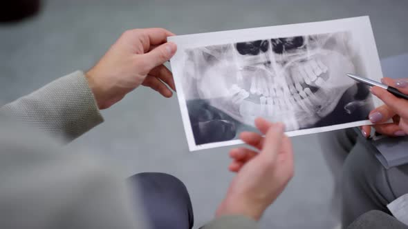 Top View of Patient and Dentist Looking at X-Ray