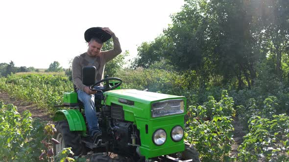 An Agronomist Inspects a Berry Crop While Riding His Mini Tractor