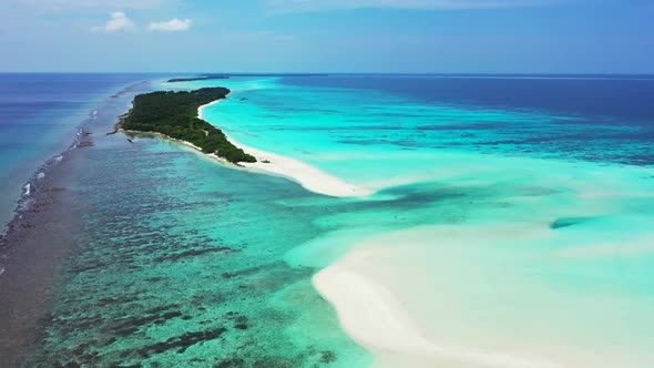 Aerial drone shot seascape of idyllic coast beach adventure by turquoise lagoon with white sand back