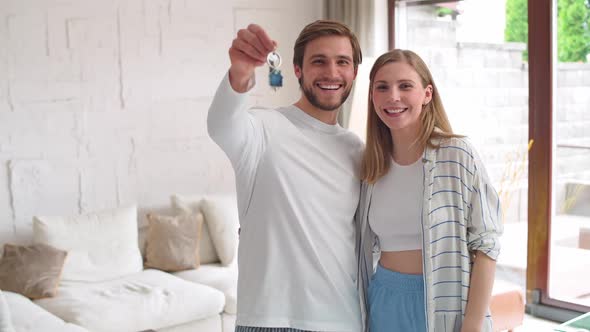 Housewarming Happy Young Couple in a New Apartment the Male Smiles and Shows the Keys to the New