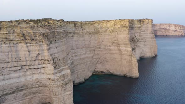 Aerial shot of high white cliff wall of Gozo island,Malta coastline.