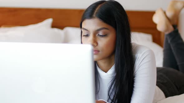 Woman using a laptop in bedroom