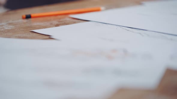 Many white sheets of paper with sketches of modern designes on the table. 