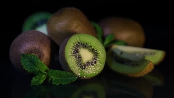 Delicious Beautiful Fruit Kiwi and Mint Lie on a Black Table