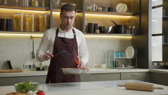 Young Chef Man Tosses Steamed Vegetables on Pan in Kitchen