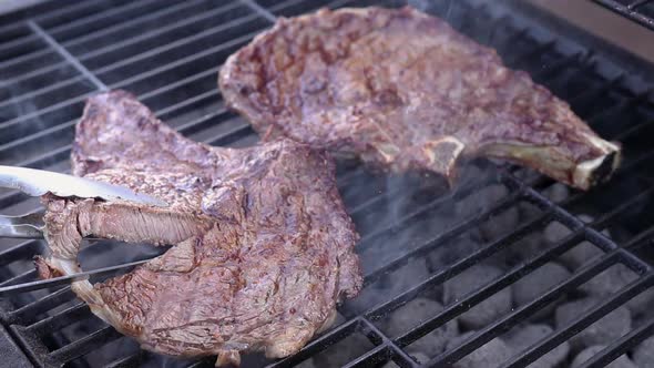 Steak on charcoal barbecue showing medium to well done degree of doneness.