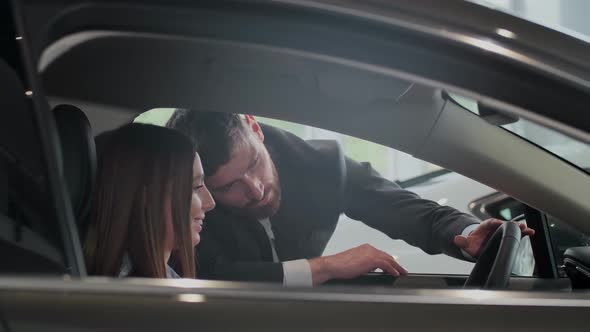 Salesman Shows the Car Features for Client. The Car Is New. Salesman Do the Best To Sell This One.