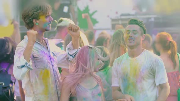 Young Men and Woman Covered in Holi Festival Colors Dancing to Music, Slow-Mo